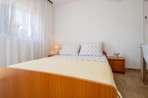 a bed with a wooden frame in a bedroom at Apartmani Frane in Neum