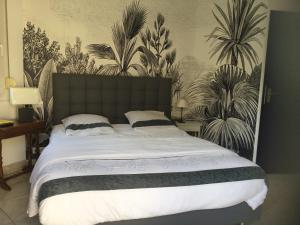 a bedroom with a large bed with plants on the wall at STUDIO BEAUREGARD - TERRASSE et JARDIN in Nancy