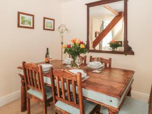 a dining room with a wooden table and a mirror at The Old School House in Hutton le Hole
