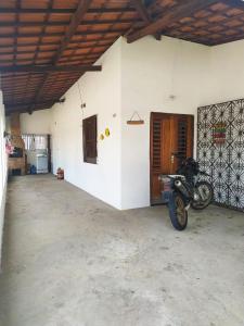 a motorcycle parked in a room with a garage at Doce Lar - Casa de Praia in Itapipoca