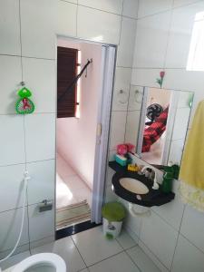 a bathroom with a toilet and a sink and a mirror at Doce Lar - Casa de Praia in Itapipoca