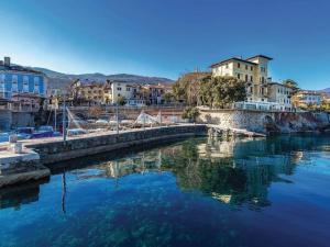 a body of water with buildings in the background at Apartman Villa Adelina in Lovran
