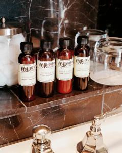 four bottles of sauce sitting on a counter above a sink at City Club Hotel in New York