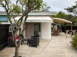une terrasse avec des chaises et des tables ainsi qu'une maison dans l'établissement Studio CAP-OCEAN cap ferret, à Cap-Ferret