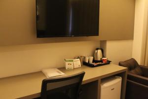 a desk in a hotel room with a tv on the wall at Holiday Inn - Goiania, an IHG Hotel in Goiânia