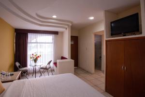 une chambre d'hôtel avec un lit et un salon dans l'établissement Hotel Arcos Aeropuerto, à Veracruz