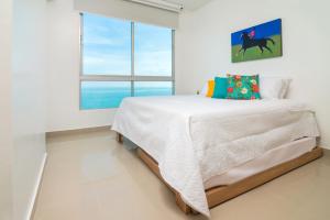 a white bedroom with a bed and a window at Magico Apartamento Frente al Mar 3 Habitaciones AR91 in Pativilca +28 photos