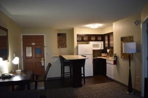 a small kitchen with a table and a refrigerator at Staybridge Suites Cranbury - South Brunswick, an IHG Hotel in Cranbury