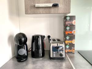 una encimera de cocina con 2 cafeteras y tostadora en Très beau T2 42m2 lumineux, moderne et rénové avec Fibre en Belfort