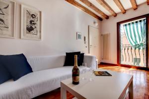 ein Wohnzimmer mit einer Flasche Wein auf dem Tisch in der Unterkunft CA ANGELA VENETIAN APARTMENT M0270428215 in Venedig