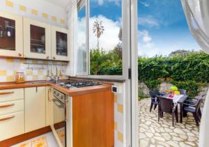 una cucina con vista su un patio con tavolo di Enjoy Home Sorrento a Sorrento