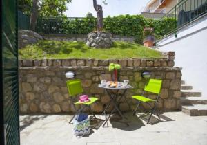 un tavolo e sedie di fronte a un muro di pietra di Enjoy Home Sorrento a Sorrento