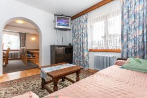 a bedroom with a bed and a table and a tv at Ferienhaus Alpenrose in Bruck an der Großglocknerstraße