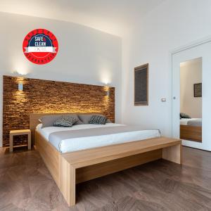 ein Schlafzimmer mit einem Bett und einer Ziegelwand in der Unterkunft Le Terrazze di Bellavista in Su Forti