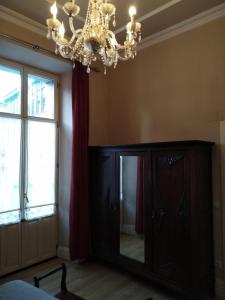 a room with a chandelier and a large mirror at APARTAMENTO HISTORICO LLANES in Llanes