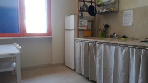 a kitchen with a white refrigerator and a window at Terra e colori in Gallipoli