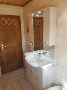 a bathroom with a sink and a mirror and a toilet at Appartamento Comelico Dolomiti in Candide +30 photos