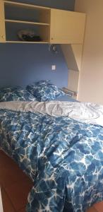 a bed with a blue comforter in a bedroom at Lacanau golf in Lacanau