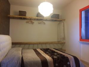 a bedroom with a bed and a light on the wall at Terra e colori in Gallipoli