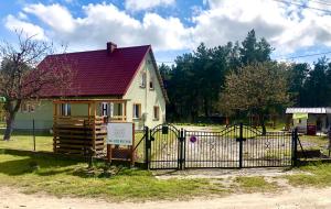 a house with a gate in front of it at Przystań Rodzinna in Kopalino