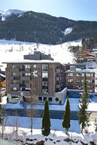 an apartment building with a pool in the snow at Hotel Edelweiss in Saalbach Hinterglemm