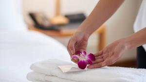 a woman placing a flower on a towel at Executive Inn Schulenburg in Schulenburg