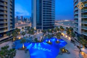 an aerial view of a resort with a blue pool at Keysplease 5* 2 B/R Apt, Damac Paramount Residence in Dubai