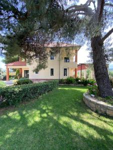 una casa grande con un árbol en el patio en Promachon Villa, en Foinikiá