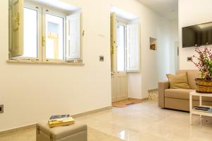 a living room with a couch and windows at La Casa Dei Ricordi in Letojanni