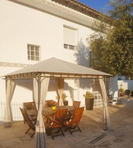 einen Holztisch und Stühle unter einem großen Sonnenschirm in der Unterkunft Apartamento vistas al mar - Coveta Fuma in El Campello