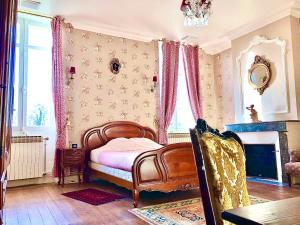 una camera con letto, camino e finestra di Chateau Gunes (Guges) a Cissac-Médoc