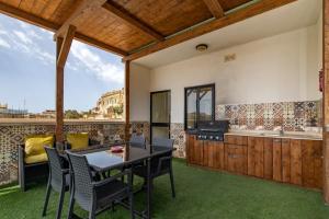 an outdoor living room with a table and chairs at Skalina in Marsaskala
