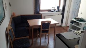 eine kleine Küche mit einem Tisch und Stühlen in einem Zimmer in der Unterkunft Emi in Klagenfurt am Wörthersee