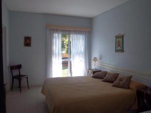 sypialnia z dużym łóżkiem i oknem w obiekcie Hotel Posada Terrazas con pileta climatizada w mieście Potrero de los Funes