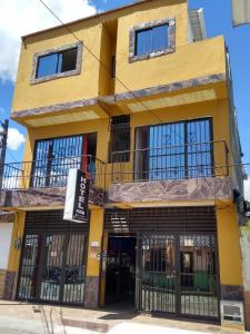 a yellow building with iron gates in front of it at Tesoro Andino in La Tebaida