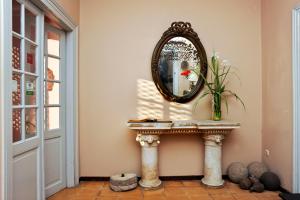 a bathroom with a mirror and a vase of flowers at Doma Hotel in Chania Town