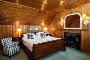 una camera con letto, sedia e camino di Hotel Eilean Iarmain a Isleornsay