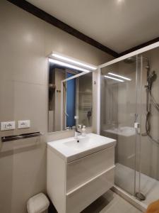een witte badkamer met een wastafel en een douche bij Downtown Apartments Merlo in Milaan