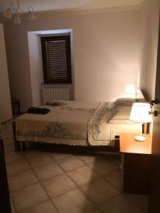 a bedroom with a bed and a table and a window at Residenza Il cortile in Monte San Martino