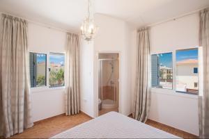 Schlafzimmer mit einem Bett und Fenstern sowie einem Kronleuchter in der Unterkunft Elite Luxury Villa in Paralimni + 66 Fotos