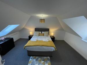 a attic bedroom with a bed and two lamps at The Old Stables 17a in Dumfries
