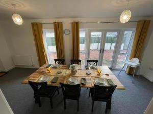 uma sala de jantar com uma mesa de madeira e cadeiras em The Old Stables 17a em Dumfries