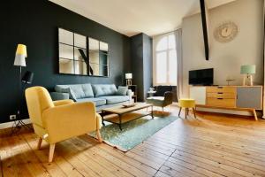 a living room with a couch and a table at Fontaines de Morny in Deauville