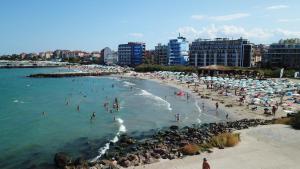 a beach with a bunch of people in the water at Golden Sun in Pomorie