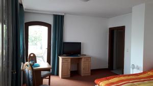 Schlafzimmer mit einem Bett und einem TV auf einem Schreibtisch in der Unterkunft Emi in Klagenfurt am Wörthersee