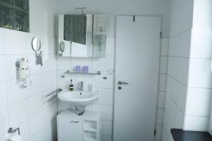 リューネブルクにあるAppartement-an-der-Ilmenauの白いバスルーム(シンク、シャワー付)