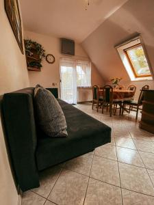 ein Wohnzimmer mit einem grünen Sofa und einem Tisch in der Unterkunft Casa Fiore By BLTN Balatonlelle in Balatonlelle