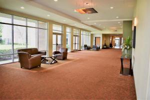 un grand hall avec des chaises, des tables et des fenêtres dans l'établissement Hyatt Place Dallas/Garland/Richardson, à Garland