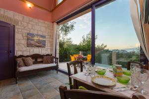 a dining room with a table and a large window at ELIA VILLA 1 in Alikanas
