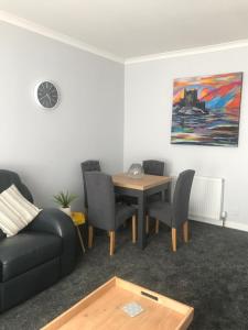 uma sala de estar com uma mesa e um sofá em 4 York Drive, Portree , Isle Of Skye em Portree